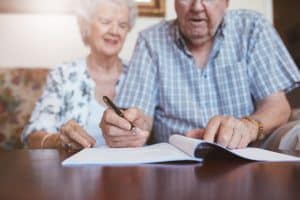 Senior,Couple,Signing,Will,Documents.,Elderly,Caucasian,Man,And,Woman